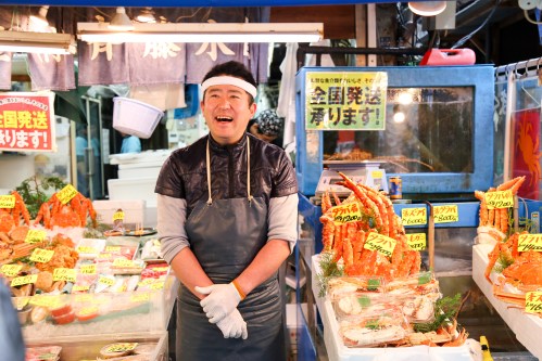 10 Day Budget Japan Tour - Men Selling Fish Have Smiling Face, Impressing Customer At Tsukiji Fish Market.