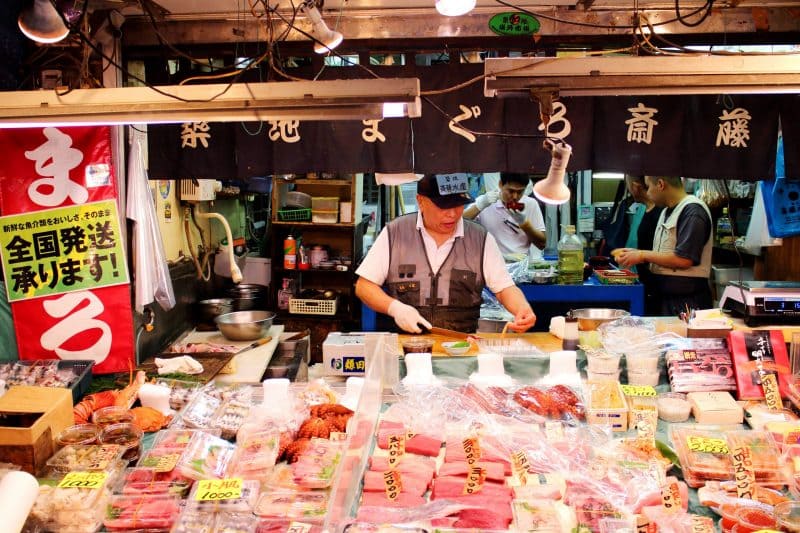 Tsukiji Market Vendors Behind Large Fish Counter.